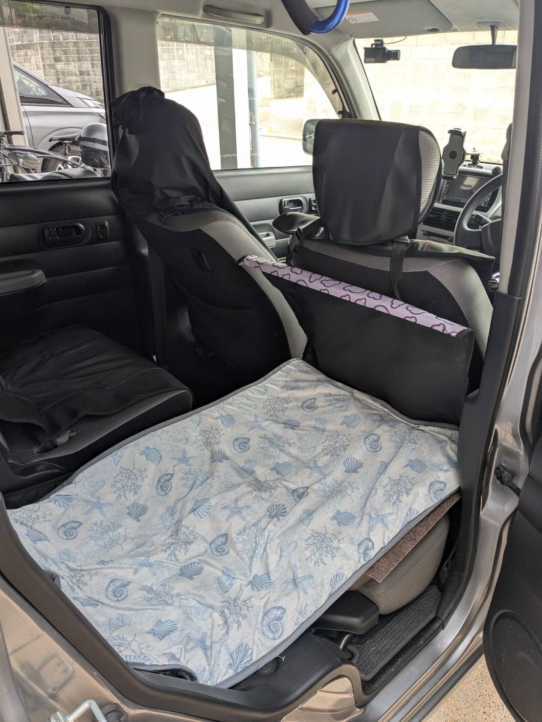 シートを倒してフラットにし、やわらかい寝具を敷いたcocoタク福岡東の車内。ケージに入れず抱っこで過ごせるシニアペット向けの空間